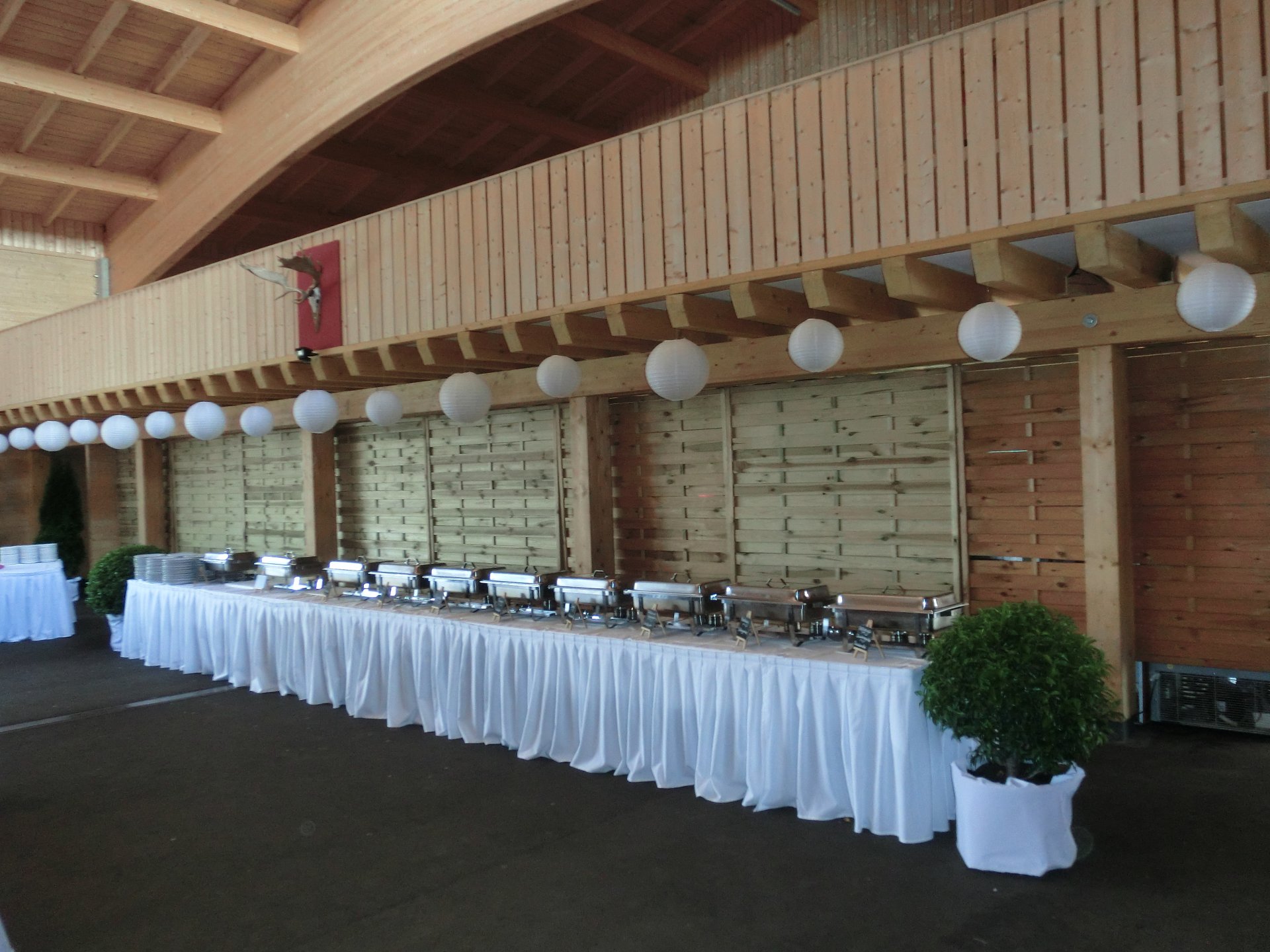Langgezogener Buffetbereich mit weißen Tischtüchern und Warmhaltebehältern